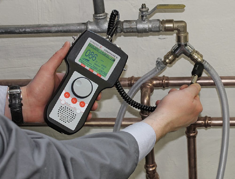 Plumber testing pipes with electronic leak detection equipment in Merritt Island