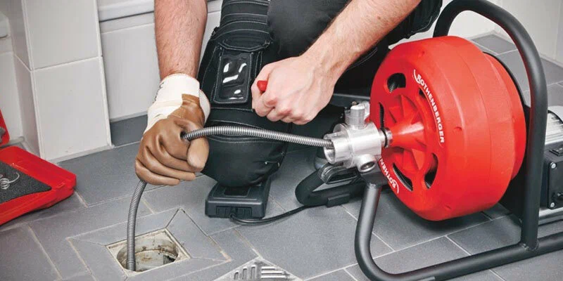 Plumber using a drain-cleaning machine in Merritt Island