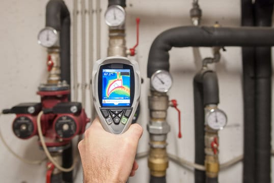 Plumber using a thermal imaging camera to inspect pipes in Merritt Island