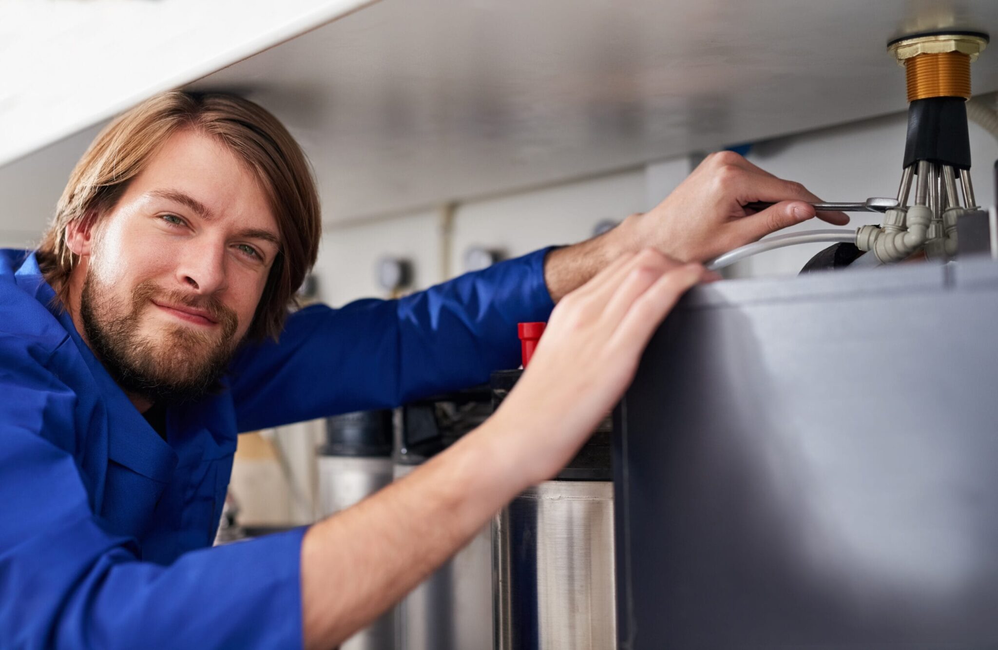 Technician servicing a residential water heater tank in Merritt Island
